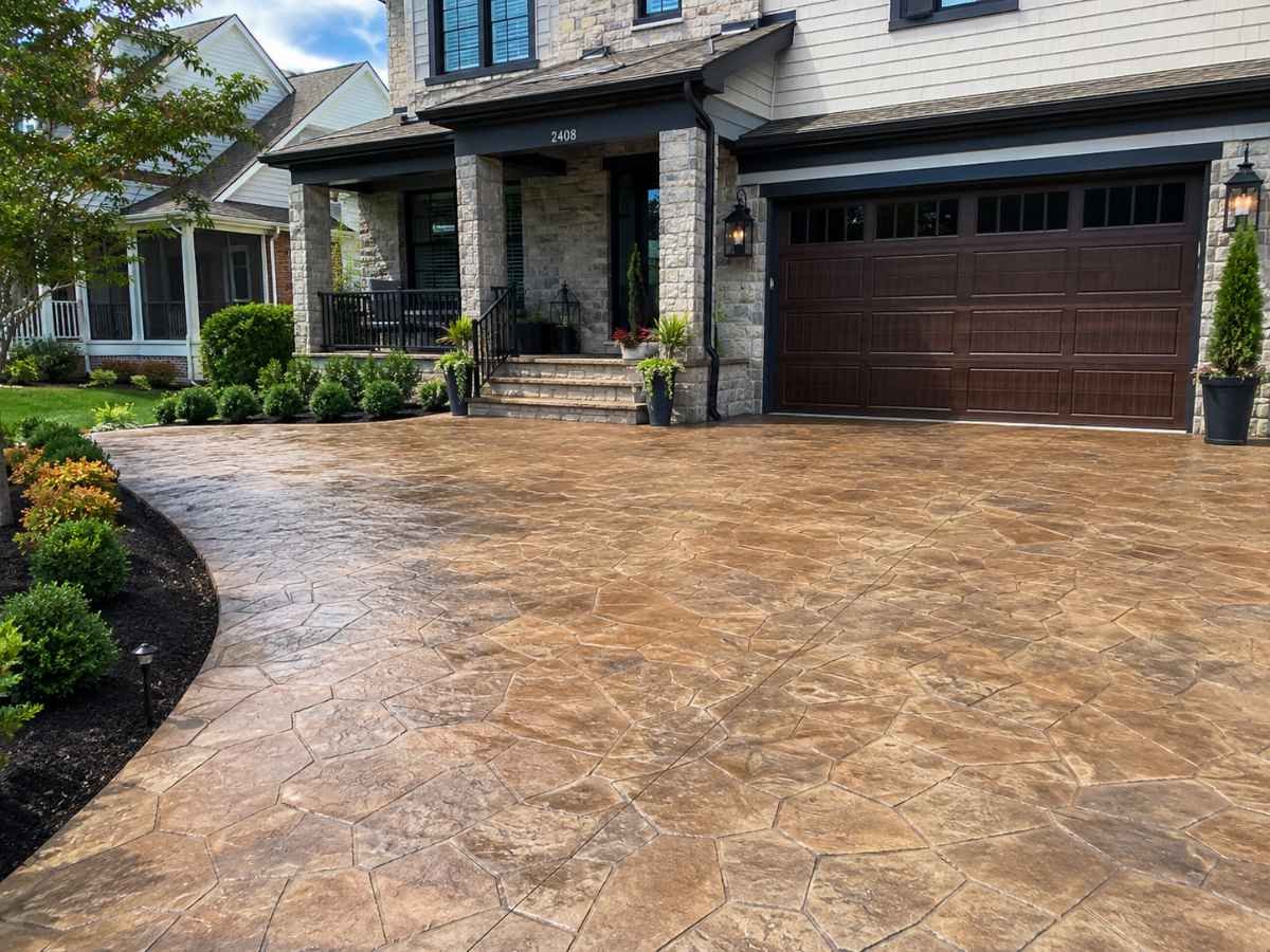 Stamped concrete driveway with stone pattern and glossy sealed finish in front of a modern suburban Arlington, Virginia home